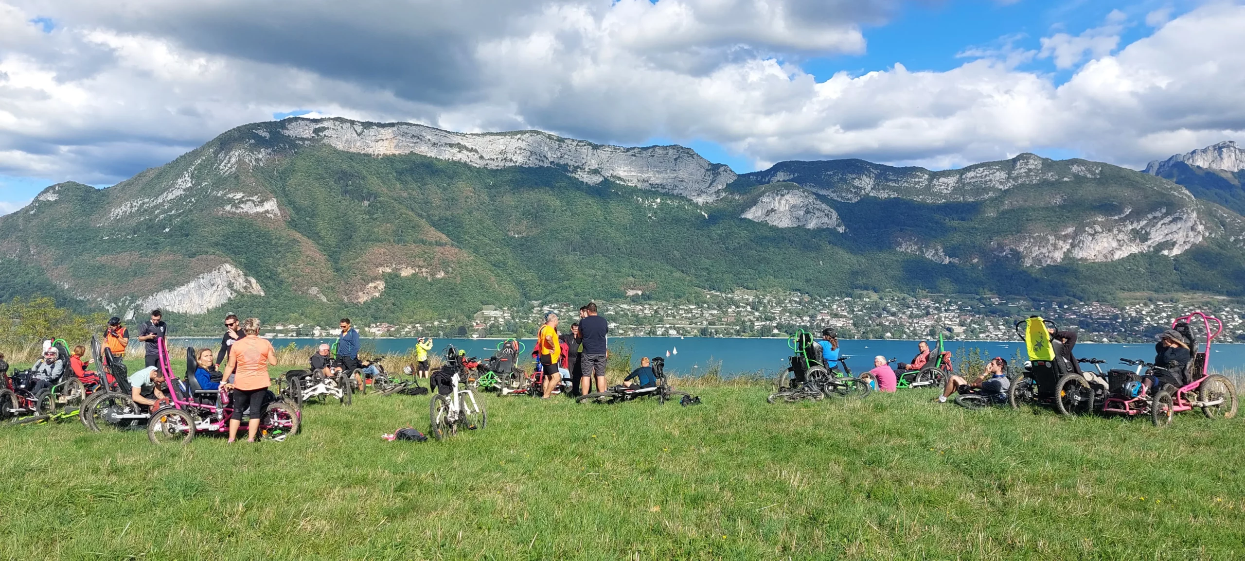 Participants du R'Handi Bike Festival qui posent devant le lac d'Annecy