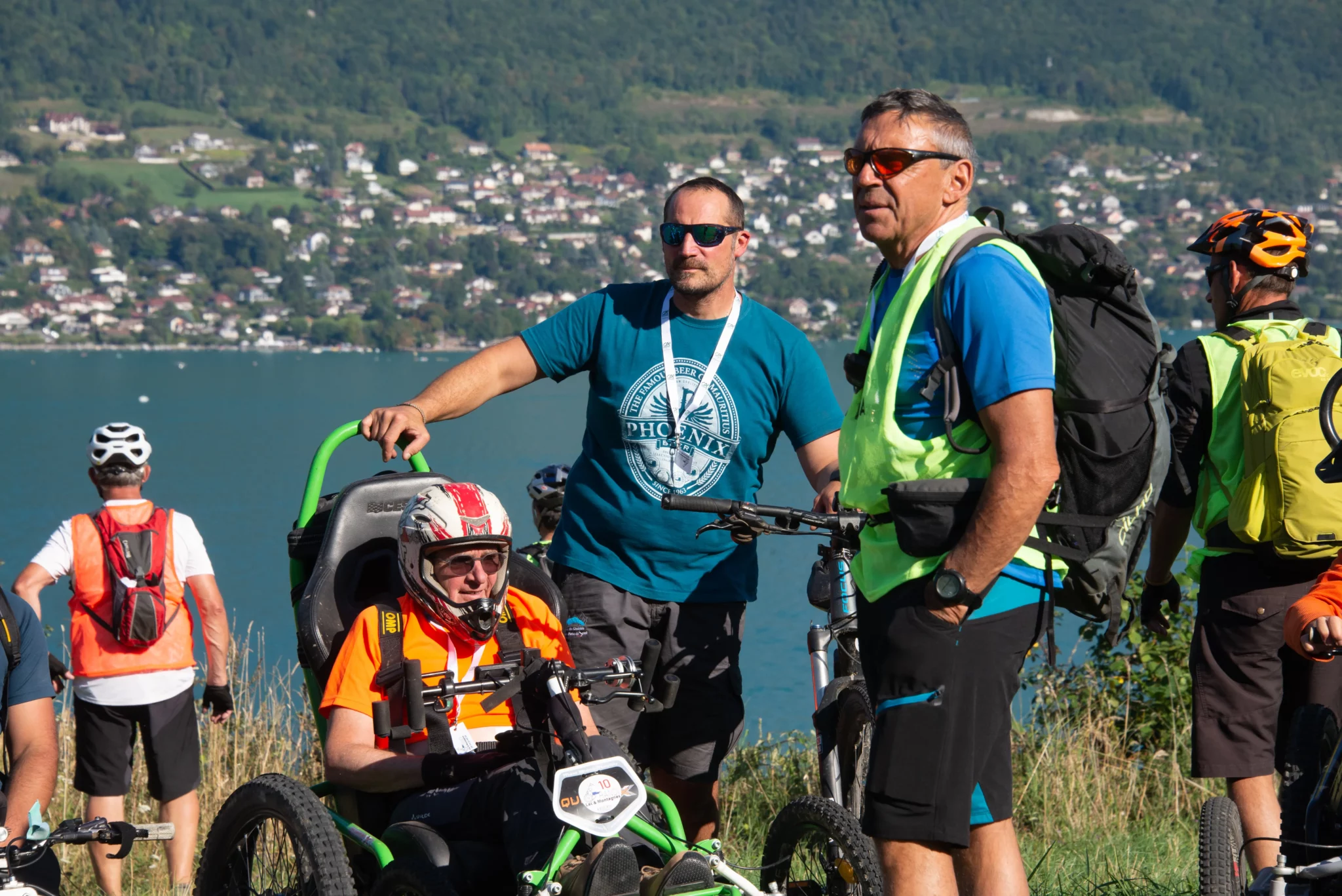 Un participant et deux accompagnateurs devant le lac d'Annecy
