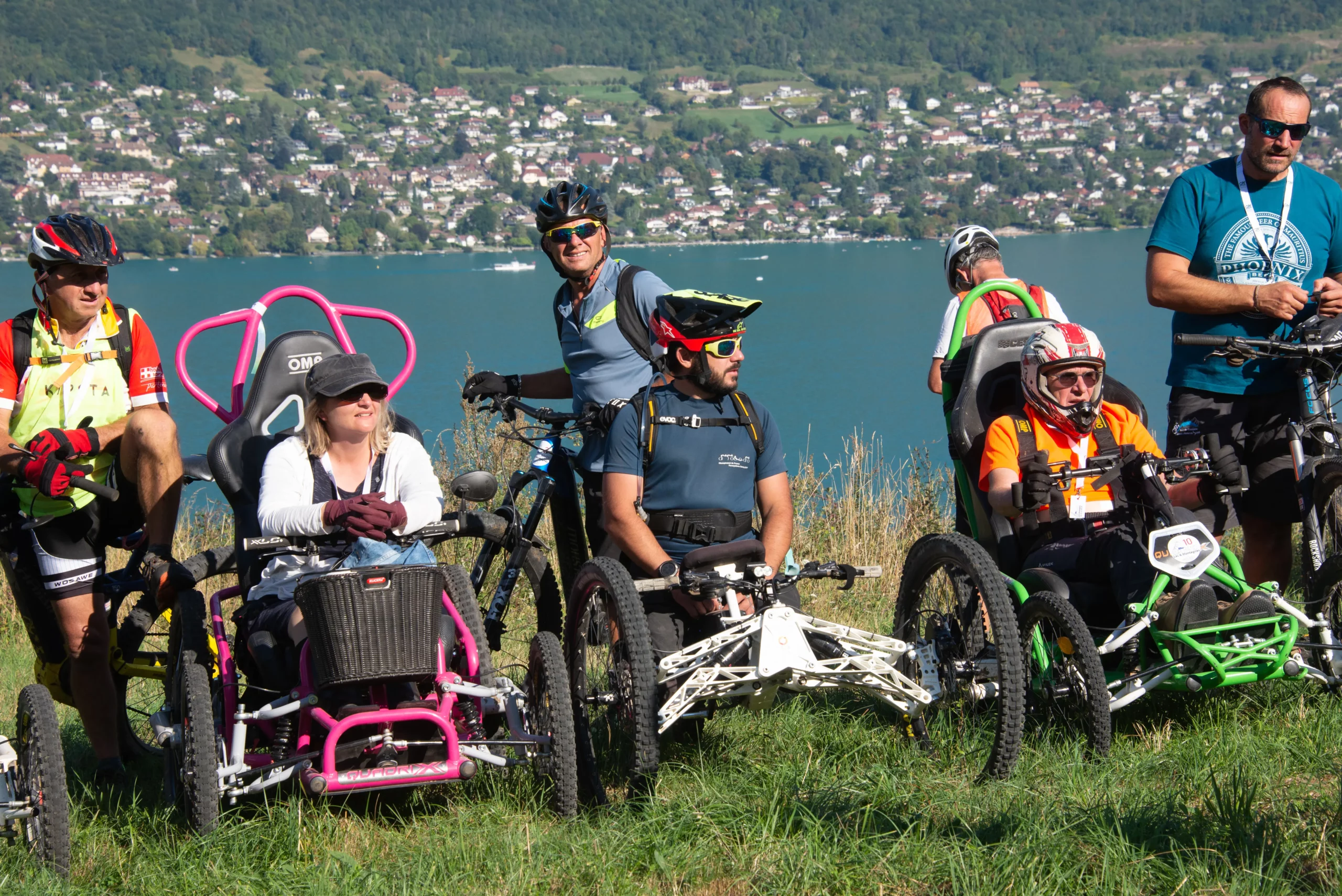 Trois participants et quatre accompagnateurs qui posent avec le lac d'Annecy en toile de fond