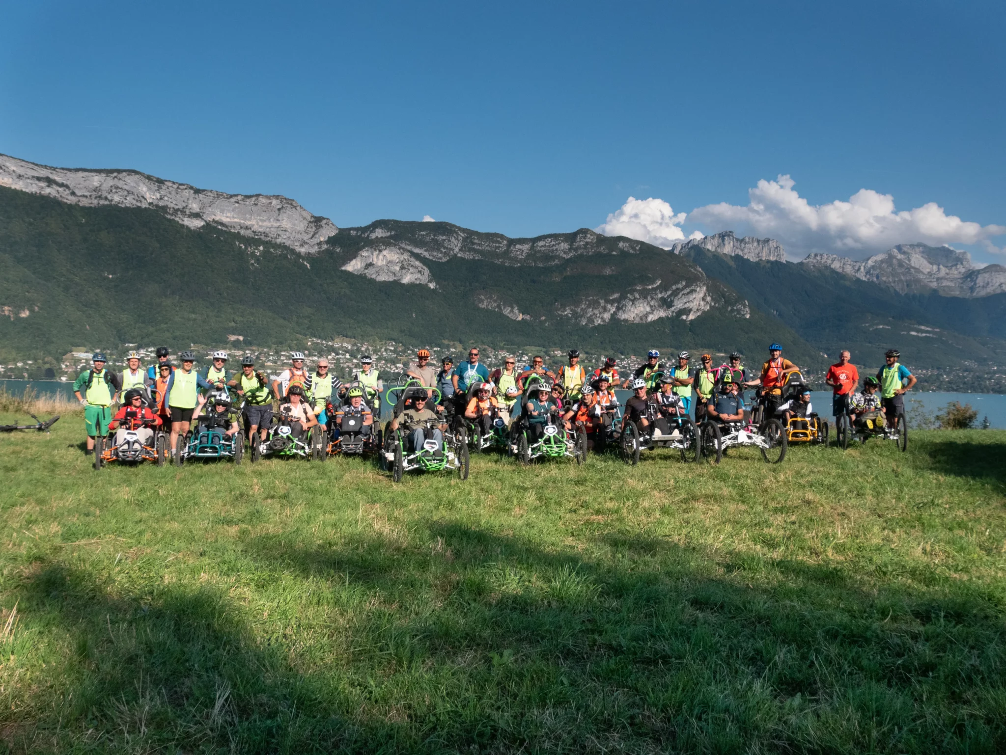 Photo de groupe avant l'arrivée avec le lac d'Annecy en fond lors du R'Handi Bike Festival