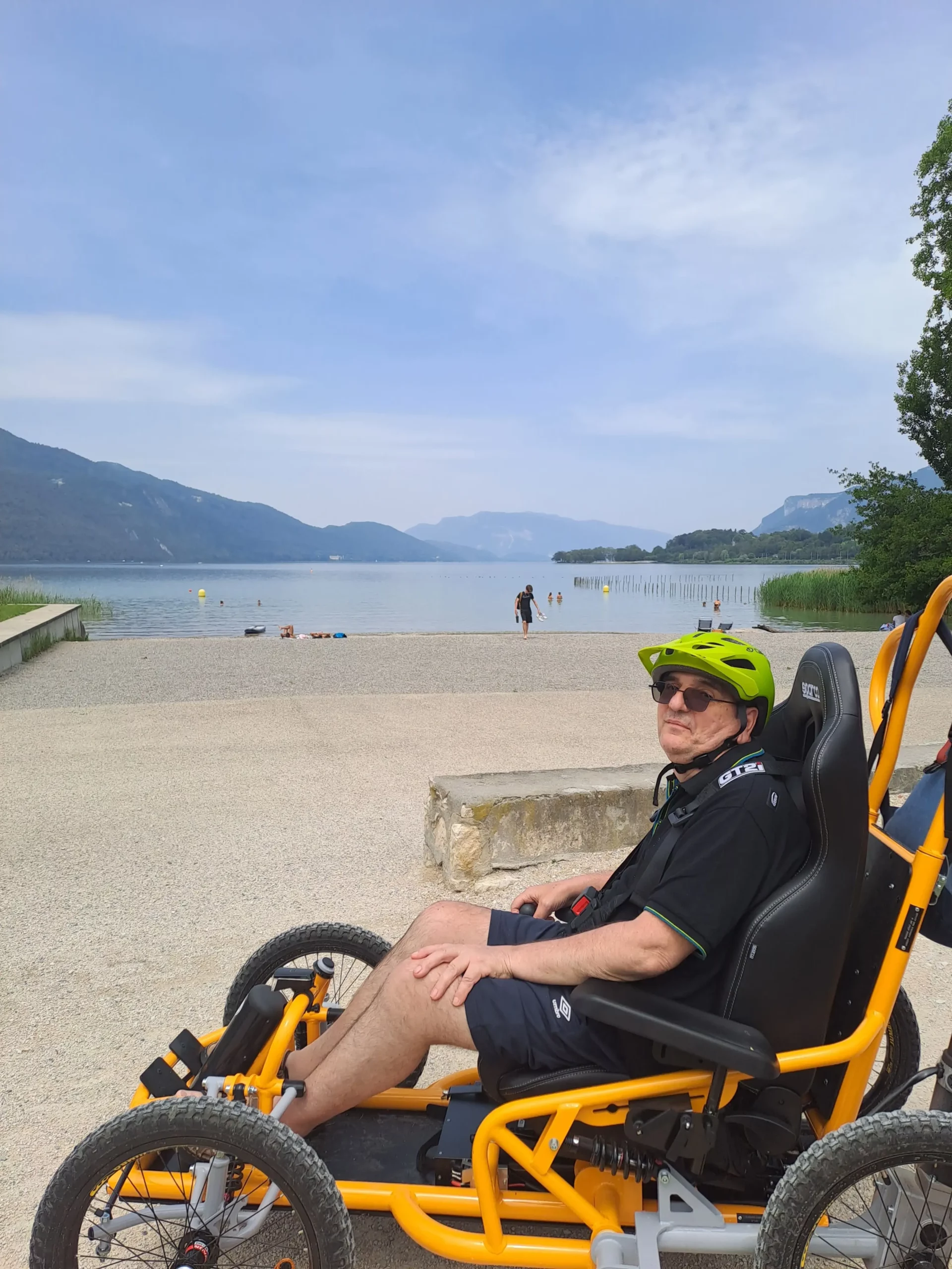 Halte au bord du lac pendant la balade avec un fauteuil tout terrain électrique de l'association Handi Lac & Montagnes