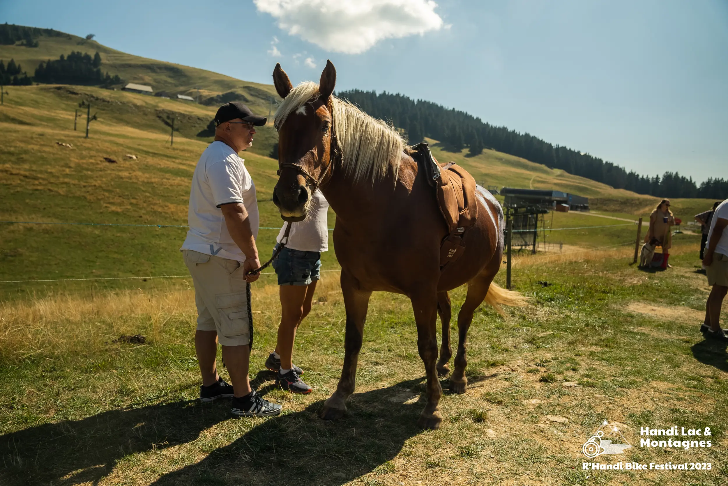 Une bénévole de Poils de Bonheur fait découvrir son cheval aux visiteurs du village du R'Handi Bike Festival 2023