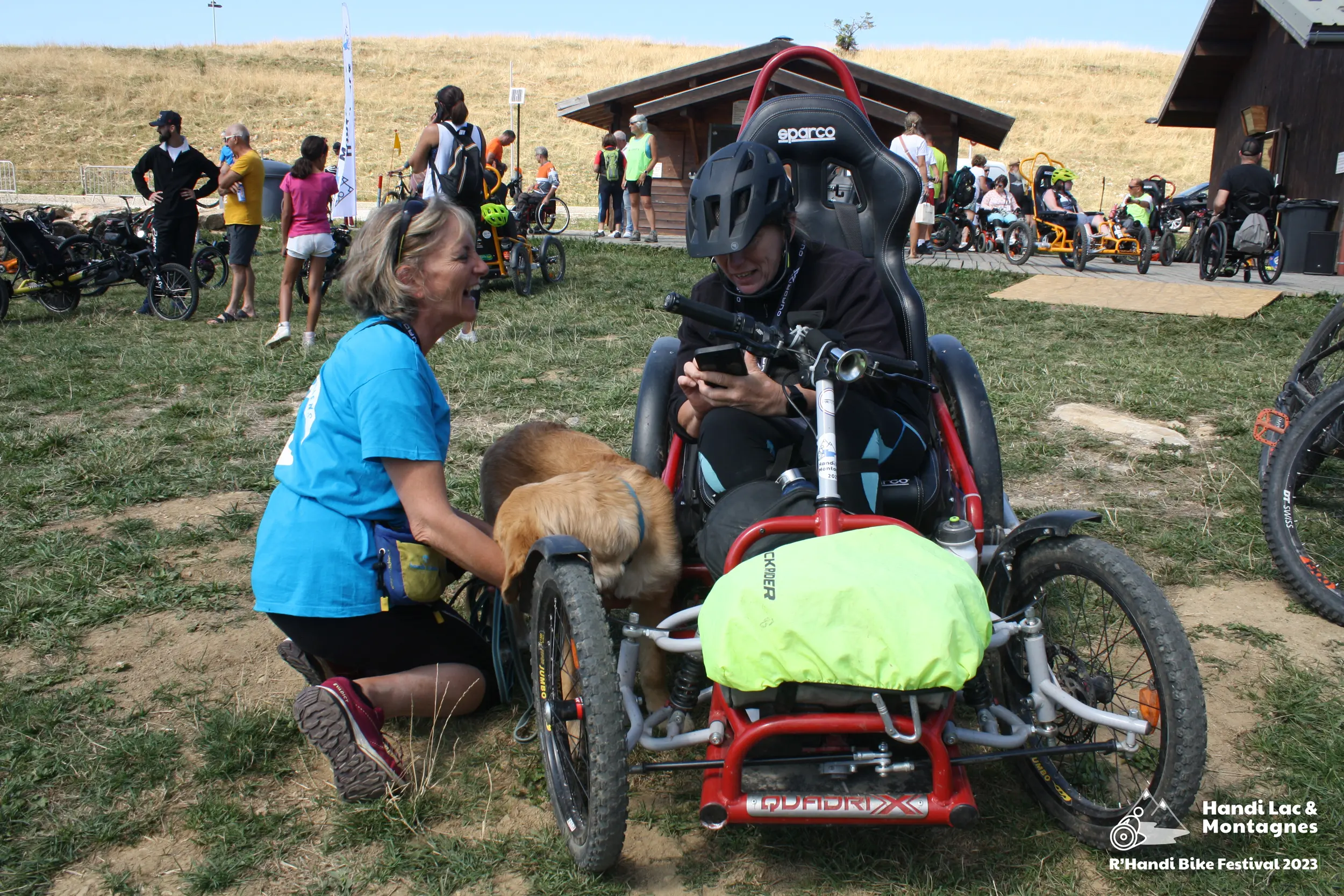 Une bénévole d'Handi Chiens fait découvrir son chien à une participante du R'Handi Bike Festival
