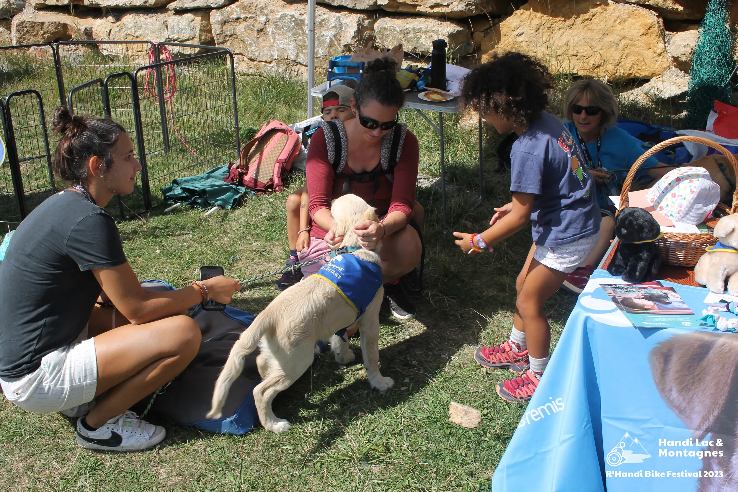 Des visiteurs découvrent les chiens du stand Handi'Chiens au Semnoz lors du R'Handi Bike Festival 2023