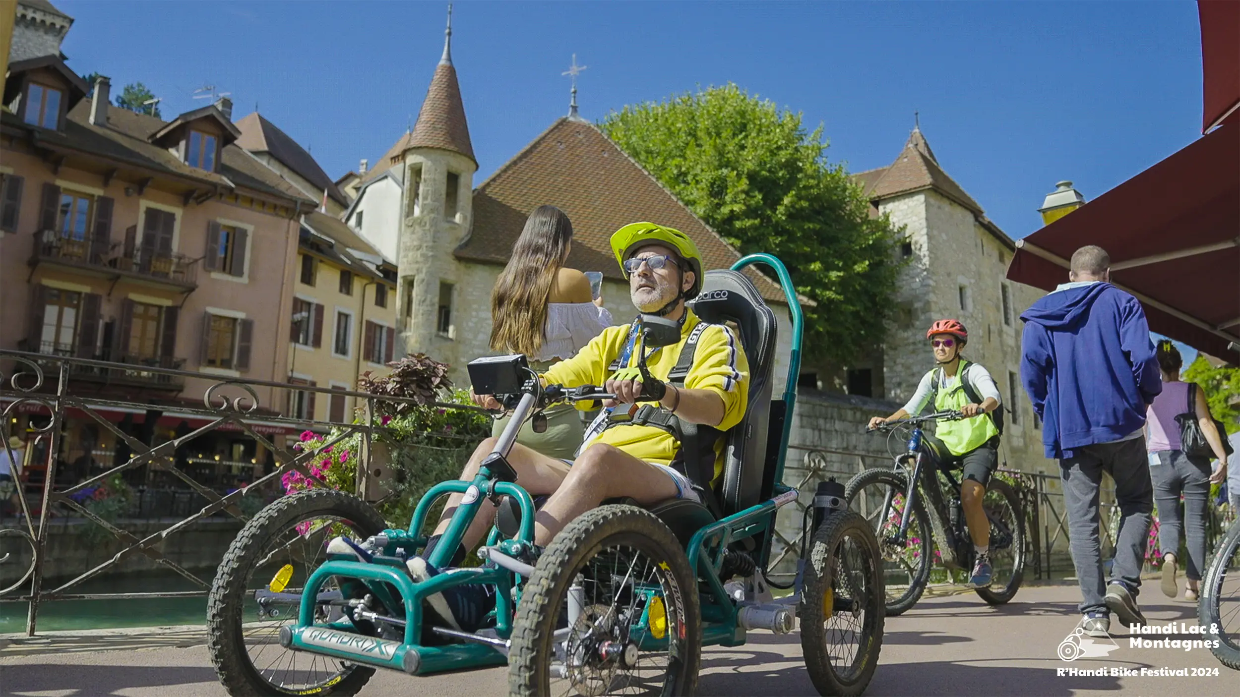 Des participants du R'Handi Bike Festival 2024 dans la vieille veille d'Annecy