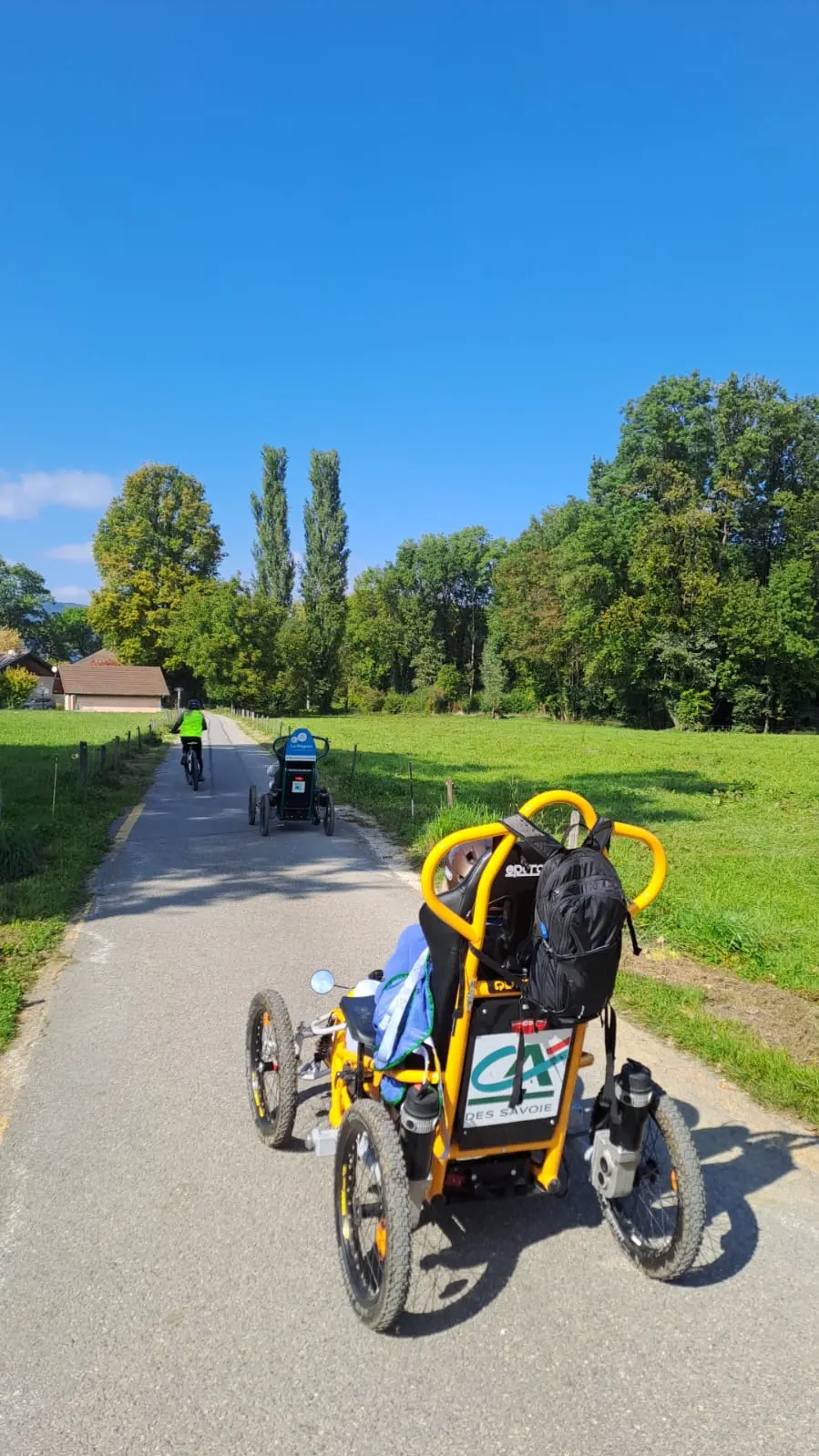 2 Quadrix de l'association Handi Lac & Montagnes avec un bénévole en VTT sur un chemin